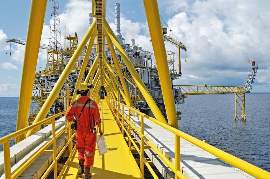 Technician walking an offshore platform walkway